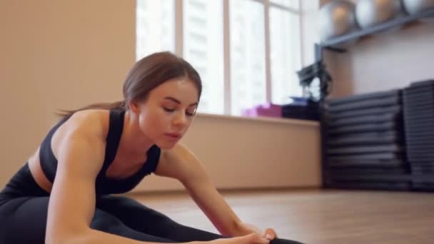 Beautiful young woman working out and stretching indoors - Video, Çekim