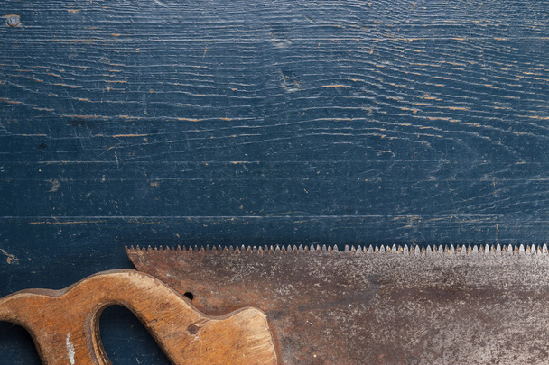 Old rusty saw on blue table - Zdjęcie, obraz