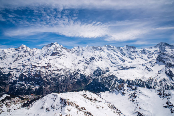 Zapierający dech w piersiach widok na słynne szczyty Monch, Jungfrau, Gletscherhorn, Abeni Flue, Mittaghorn, Grosshorn i Breithorn. Wioska Murren i dolina Lauterbrunnen poniżej. Alpy Szwajcarskie, Szwajcaria - Zdjęcie, obraz