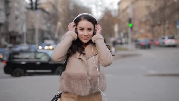 Woman listening to music in big headphones - Materiaali, video