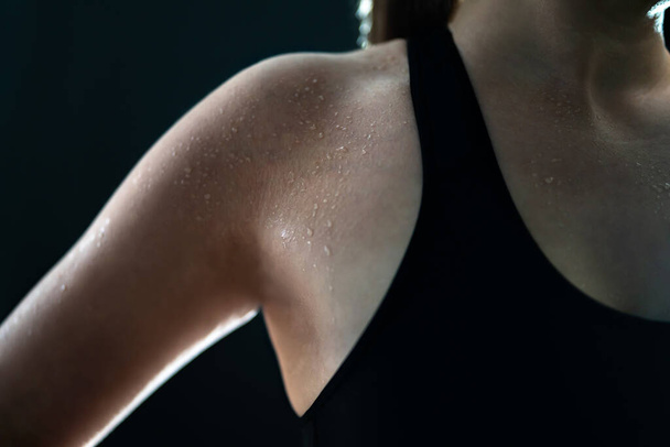 Sweaty woman after gym workout, heavy cardio or fat burning training. Sweat on wet skin. Tired fitness athlete, yoga instructor or personal trainer. Exhausted after exercise. Arm and armpit. Low key. - Photo, Image