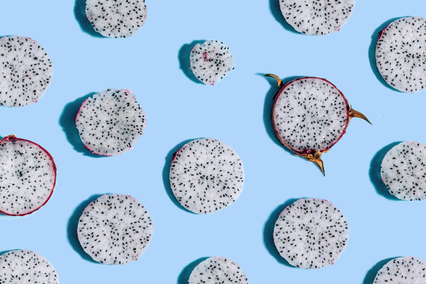 Geschnittenes Drachenfruchtmuster auf blauem Hintergrund mit freiem Kopierraum. Verschiedene Größen, mit und ohne Haut - Foto, Bild