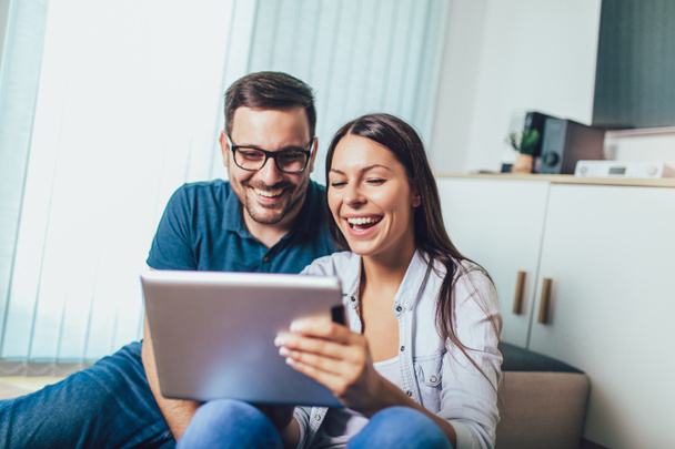 Happy νεαρό ζευγάρι απολαμβάνει χρόνο online σε ψηφιακή δισκίο. - Φωτογραφία, εικόνα