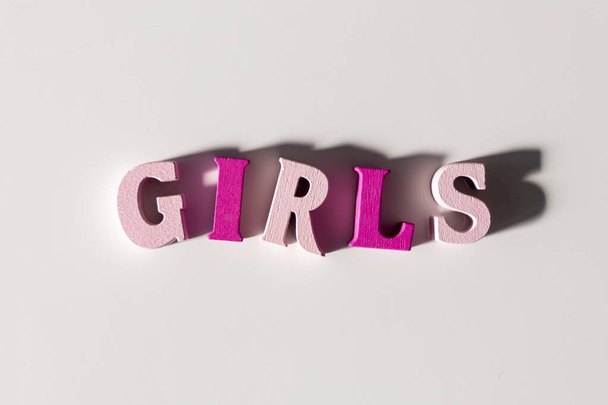Girls made of pink wooden Letters isolated on a White Background - 写真・画像