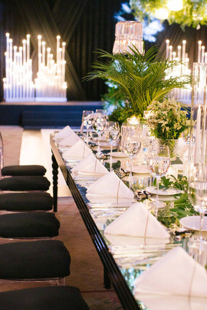 Palm tree leaf wedding table. Candles, napkins and mirrored tables. - Photo, Image