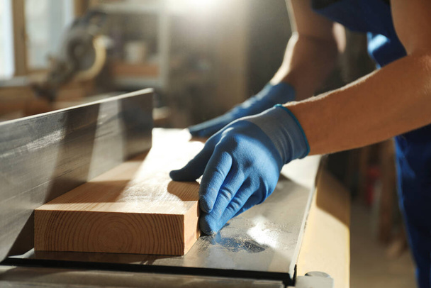 Professional carpenter working with wood in shop, closeup - Photo, Image