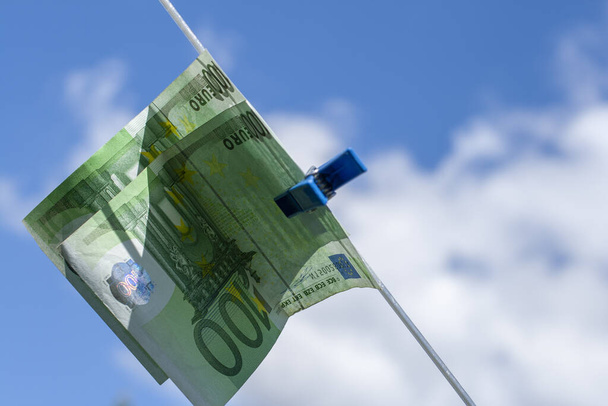 100 eurobankbiljetten op een waslijn. Thema witwassen van geld. - Foto, afbeelding