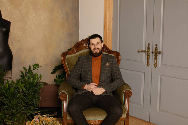 Respectable young bearded man in a room with classic interior. Luxury. Men's beauty, fashion. - Fotografie, Obrázek