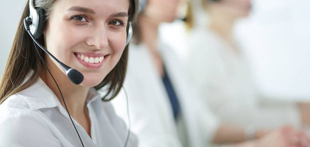 Usmívající se podnikatelka nebo operátorka telefonní linky se sluchátky a počítačem v kanceláři - Fotografie, Obrázek
