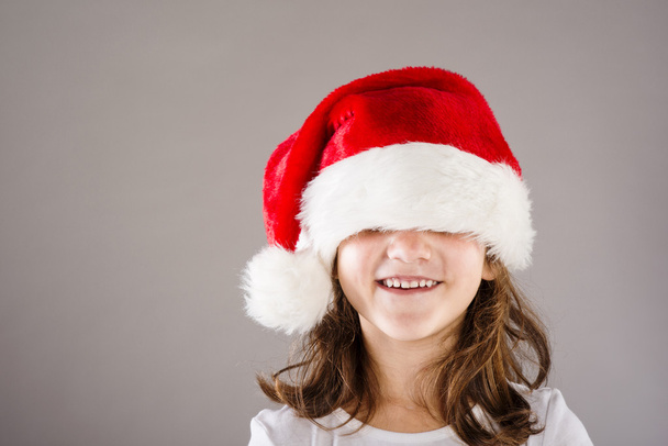 Small girl in santa hat with christmas gift - Photo, Image
