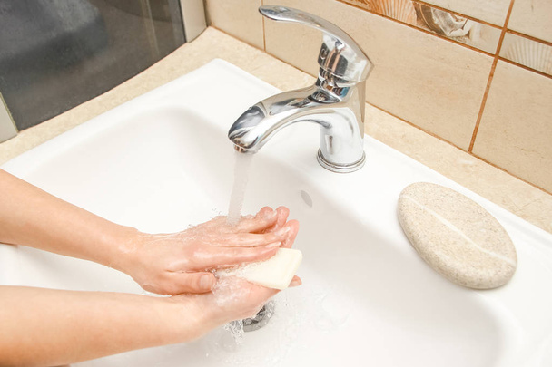 Käsien pesu saippualla hanan alla vedellä - Valokuva, kuva