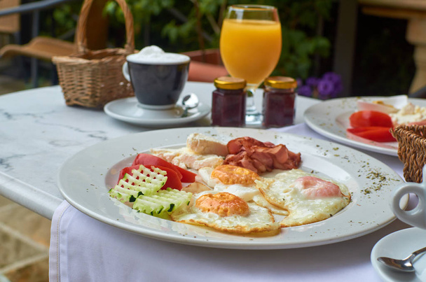 Богатый, вкусный завтрак с соком ана капучино подается на открытом воздухе
 - Фото, изображение