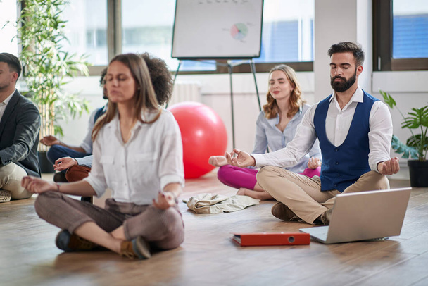 Business man meditating at work.group of business coworkers meditating together at work. - Foto, Bild
