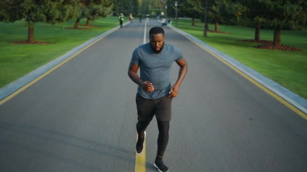 A kocogó elkezd futni a parkban. Koncentrált sportoló kocog a szabadban - Felvétel, videó