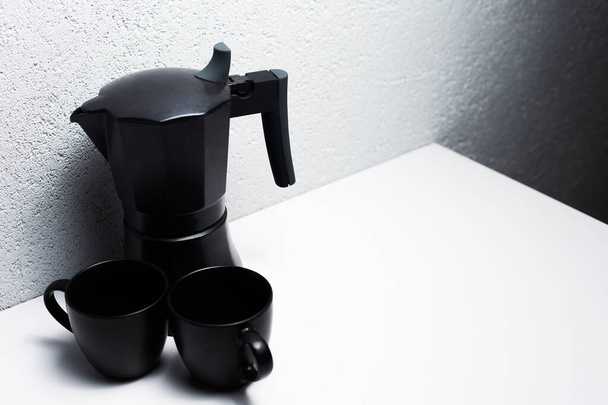 Zwarte koffie moka pot en twee kopjes, op wit. - Foto, afbeelding