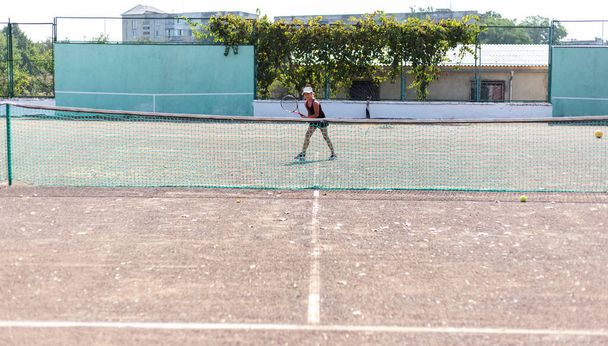 Портрет дівчини-підлітка, яка грає в теніс на спортивному корті
. - Фото, зображення