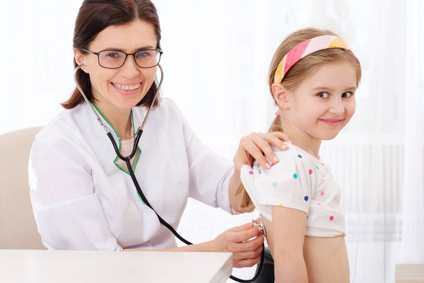 Doctor listening to girl with stethoscope - Фото, зображення
