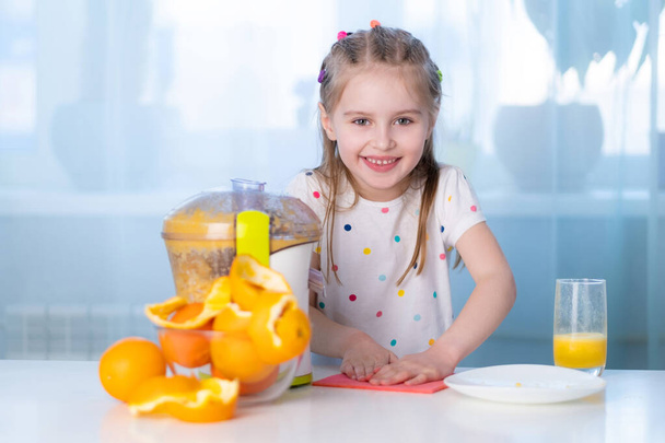 Happy kid making orange juice - Fotó, kép
