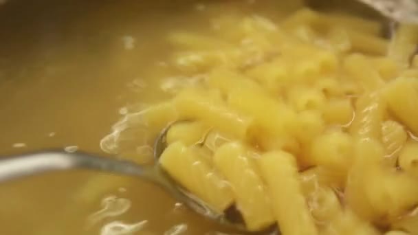 Closeup view of stiring pasta in boiling water with spoon - Felvétel, videó
