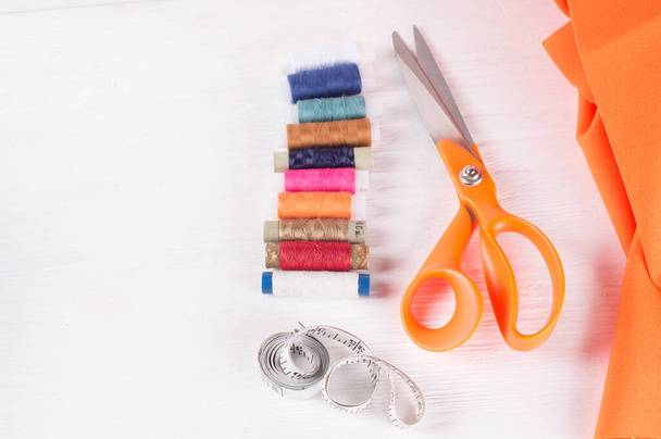 tailor scissors, inch, centimeter tape, sewing thread on white wooden  background - 写真・画像