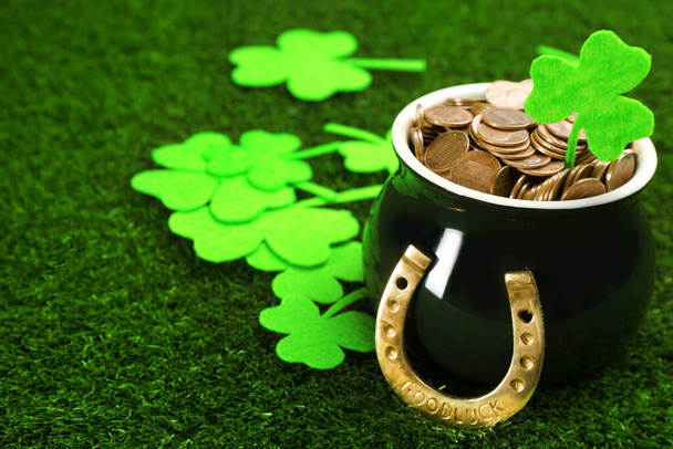 Pot of gold coins, horseshoe and clover leaves on green grass, space for text. St. Patrick's Day celebration - Fotografie, Obrázek