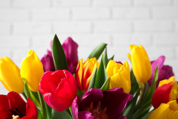 Beautiful spring tulips near white brick wall, closeup - Foto, immagini