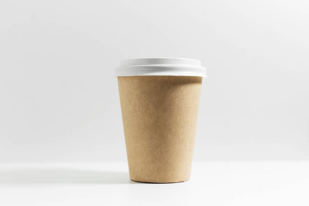 コーヒー用の使い捨て紙コップのクローズアップは、白い蓋付きで、白い背景に隔離されています。. - 写真・画像