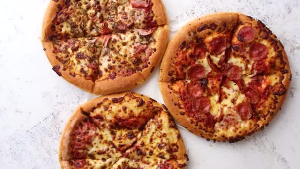 Trzy amerykańskie pizze serwowane na stole - Materiał filmowy, wideo