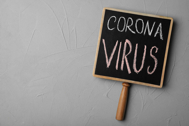 Chalkboard with phrase CORONA VIRUS on light grey background, top view. Space for text - Foto, afbeelding