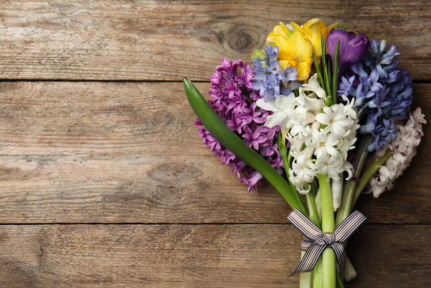 Hermosas flores de primavera en la mesa de madera, vista superior. Espacio para texto
 - Foto, Imagen