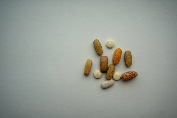 A variety of pills on a plain background. - Photo, Image