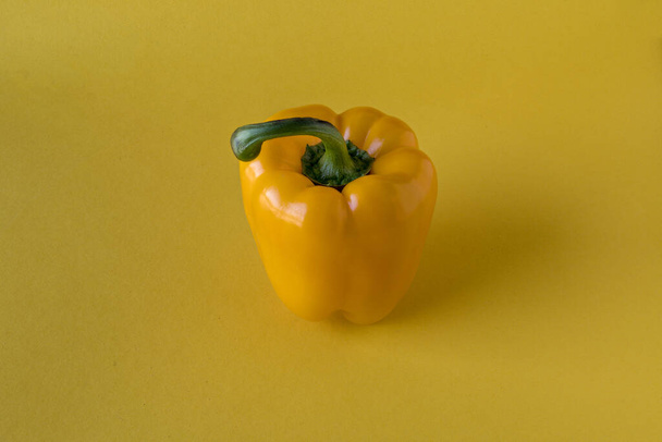 Yellow bell pepper, centered on yellow background - Foto, imagen