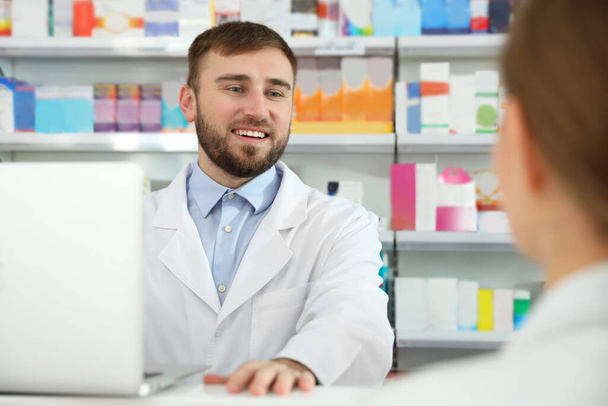 Farmacêutico profissional trabalhando com o cliente na farmácia moderna
 - Foto, Imagem