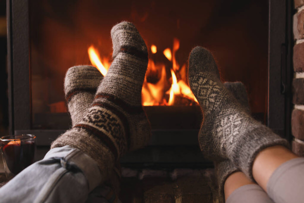 Couple resting near fireplace indoors, closeup. Winter vacation - Photo, Image