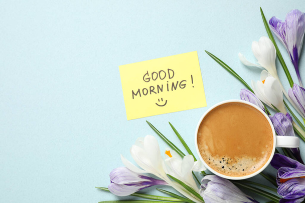 Delicious coffee, flowers and card with GOOD MORNING wish on light background, flat lay. Space for text - Foto, afbeelding