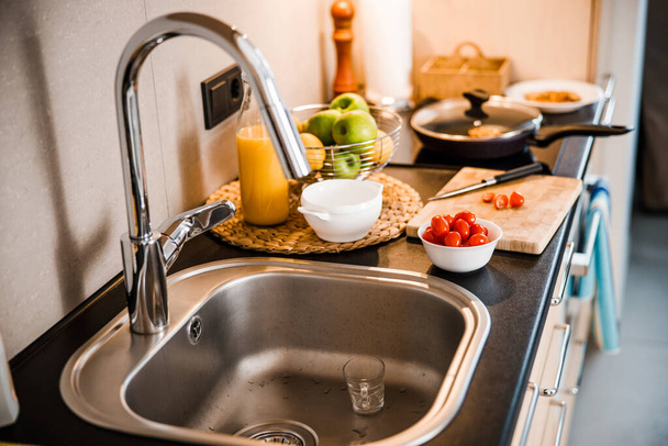 Kitchen with stainless steel faucet and healthy food - Φωτογραφία, εικόνα