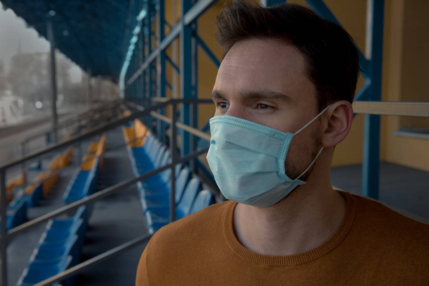 Чоловіки в хірургічній масці тримають пляшку медичних таблеток проти коронавірусу в Китаї, лікар-аптекар тримає таблетки в руці, щоб вилікувати епідемічні захворювання як лікування, пацієнт в масці один на стадіоні
 - Фото, зображення