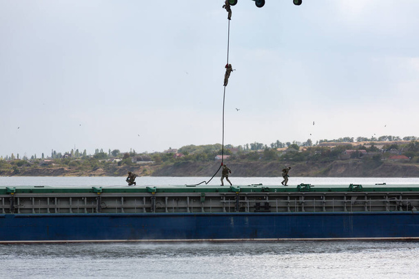 Soldados descienden de un helicóptero a una barcaza
 - Foto, Imagen