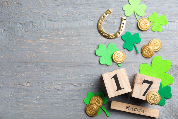 Flat lay composition with horseshoe and block calendar on grey wooden background, space for text. St. Patrick's Day celebration - Valokuva, kuva