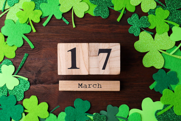 Flat lay composition with block calendar on wooden background. St. Patrick's Day celebration - Photo, image