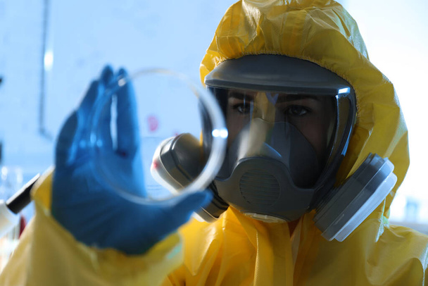 Scientist in chemical protective suit with Petri dish at laboratory. Virus research - Foto, Imagem