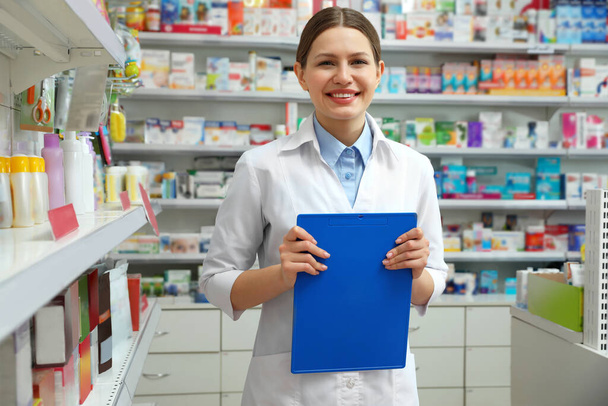 Professional pharmacist with clipboard in modern drugstore - Foto, afbeelding