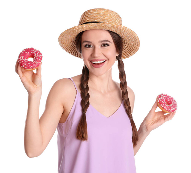 Beautiful young woman wearing stylish hat with donuts on white background - Fotografie, Obrázek