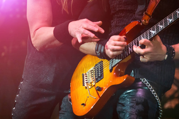 A virtuoso guitar solo. The vocalist imitates the guitarist with his hand. - Photo, Image