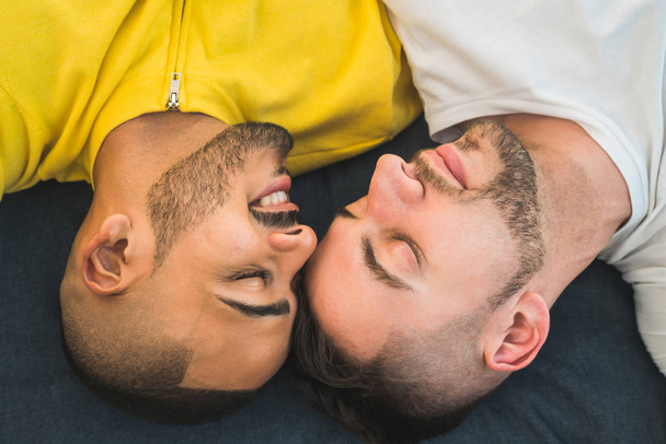 Portrait of a happy gay couple spending time and laying down on the floor. Lgbt and love concept. - Fotografie, Obrázek