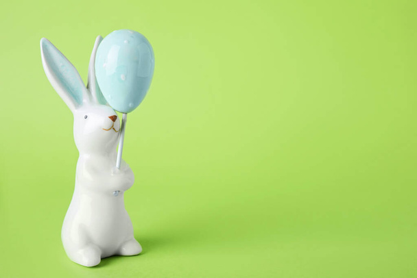 Easter bunny figure on green background. Space for text - Фото, изображение