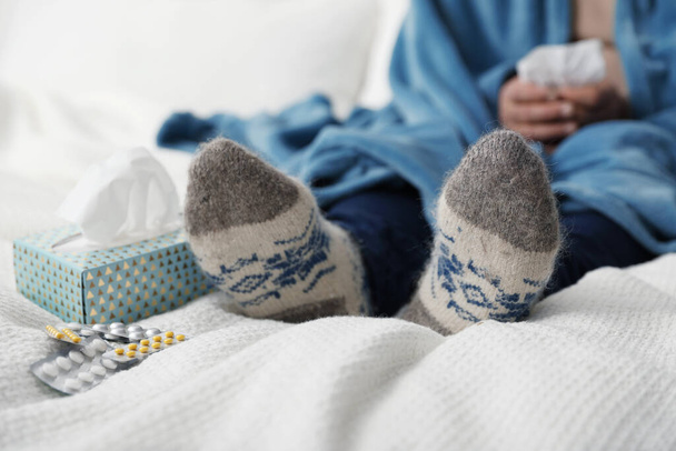Mature man and cold remedies on bed, closeup. Dangerous virus - 写真・画像