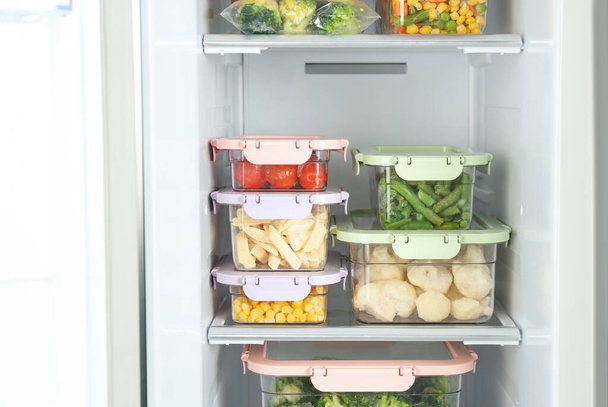 Containers with different frozen vegetables in refrigerator - Fotoğraf, Görsel