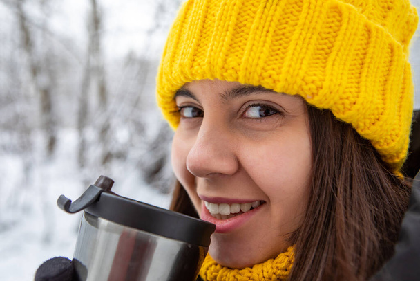 χαμογελαστή γυναίκα σε χειμωνιάτικο ντύσιμο πίνοντας ζεστό ρόφημα από ξαναγεμιστό χώρο αντίγραφο κούπα - Φωτογραφία, εικόνα