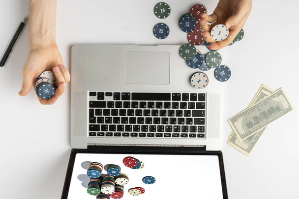 pessoa aérea jogando os jogos de apostas online em casa e ganhar o dinheiro, a pilha de fichas na tela do gadget
 - Foto, Imagem